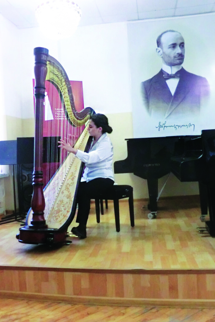 Hasmik Mkrtchyan plays in front of a Komitas portrait.